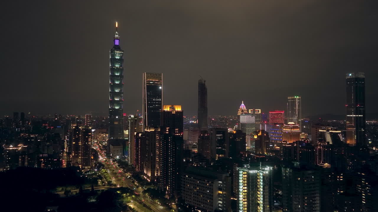 Slow aerial approaching shot of lighting skyline in Taipei City at night, Taiwan