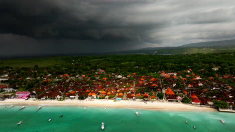 dark storm clouds over seaside town of nusa lembongan island in bali, indonesia