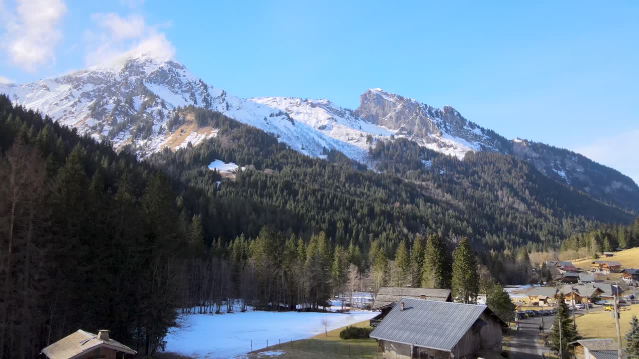 pequeño pueblo l'reringe situado junto a grandes montañas en los alpes franceses rodeado de bosque de pinos