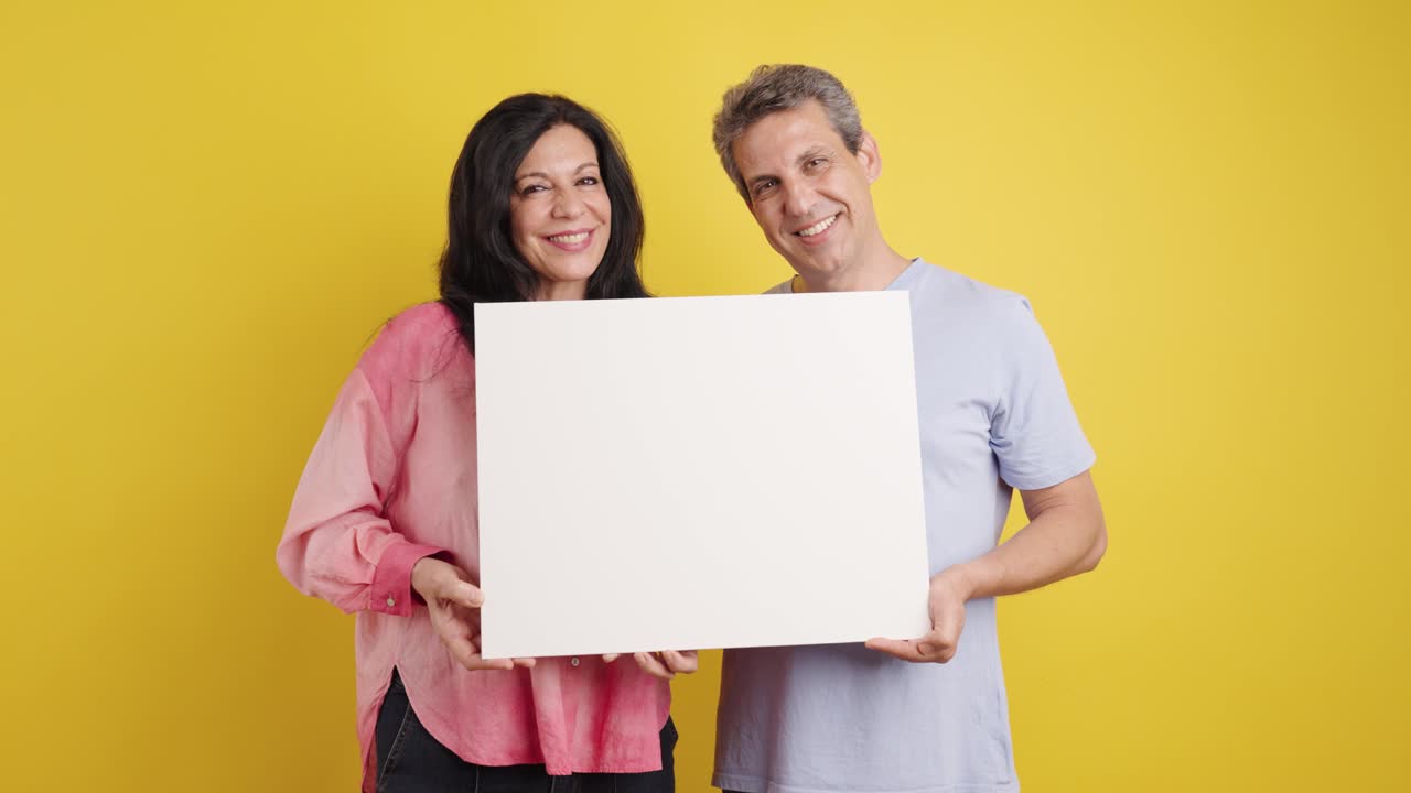Couple holding a blank sign