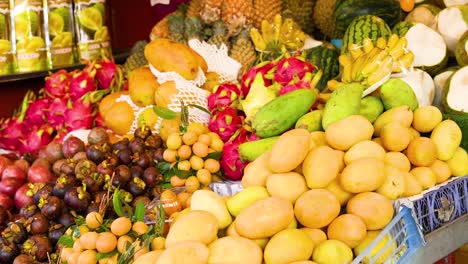 colorful display of tropical fruits at a bustling market in phuket, captured in bright daylight