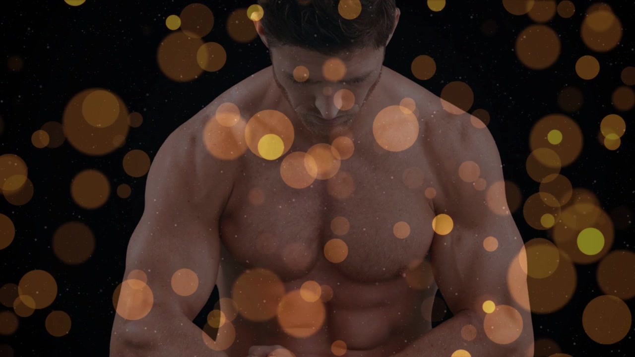 Male fitness model moving arms forward while camera pulling back, golden bokeh highlighting chest