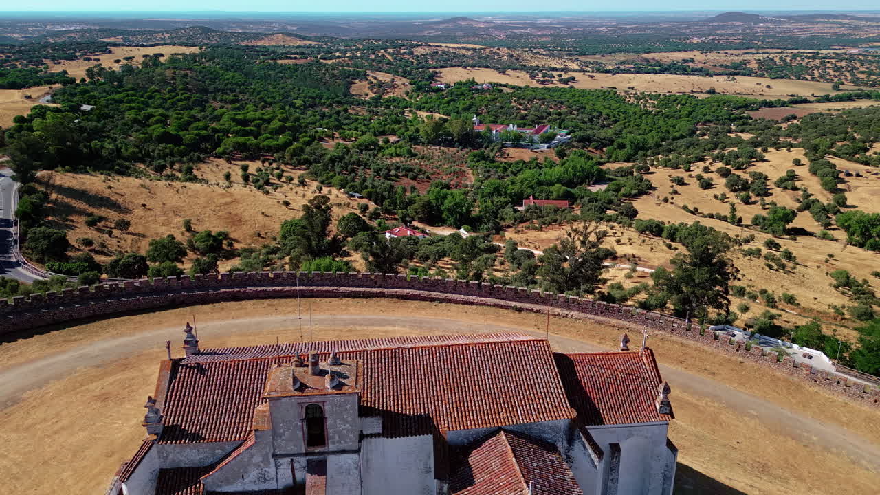 Fortezza medievale vista da drone circondata da campi. Mura in pietra che circondano la cappella.