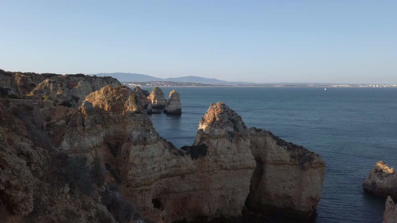 оглядываясь назад в лагос, португалия, на известняковые прибрежные скалы в сунете