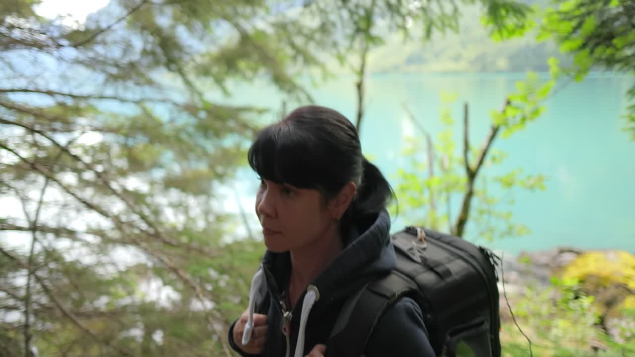 하이킹 여자 는 봄 의 녹색 숲 에서 하이킹 배 ⁇  을 들고  ⁇ 다