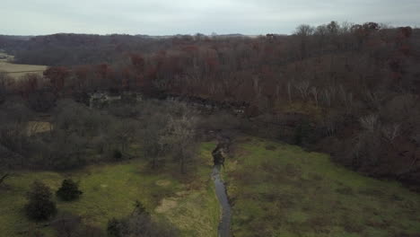 drone following creek to reveal iowa farmland and autumn colours