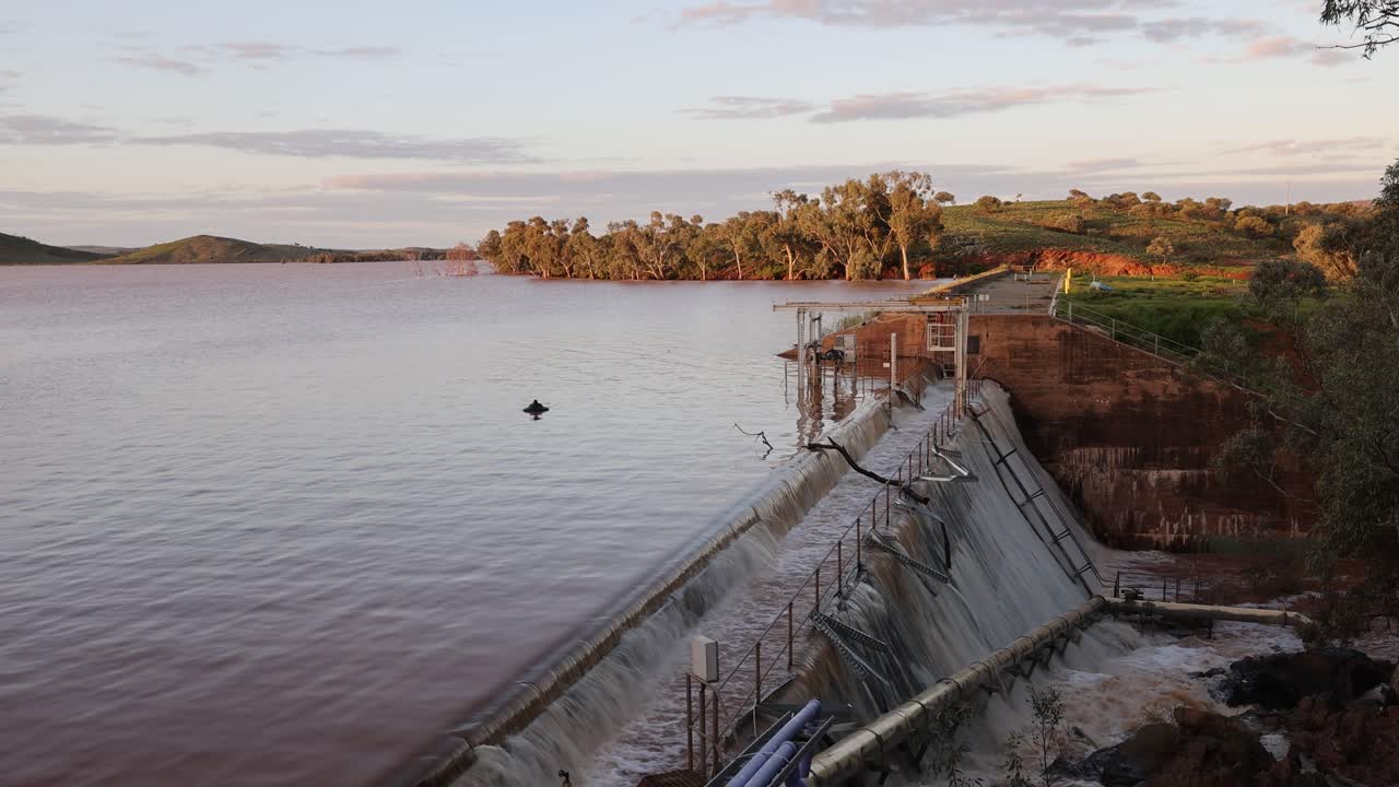aguas de inundación que caen en cascada sobre el muro de una presa en el interior de australia