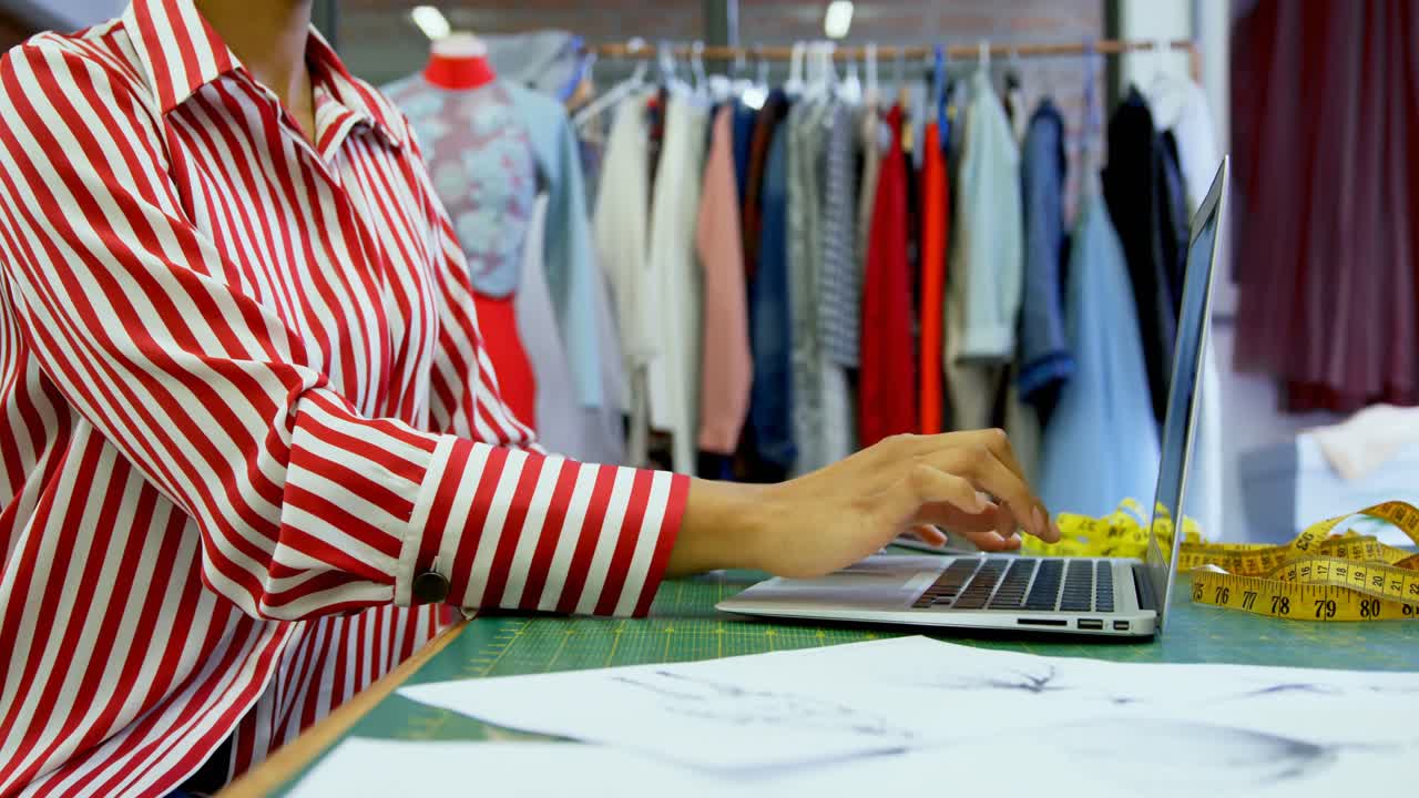 패션 스튜디오 4k에서 노트북을 사용하는 패션 디자이너