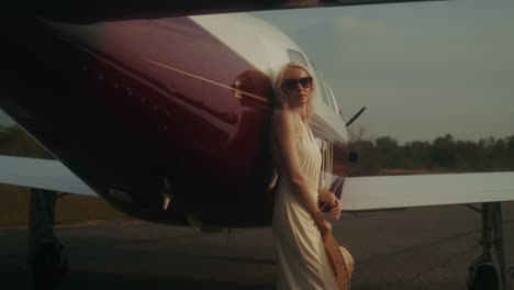woman by private jet at sunset