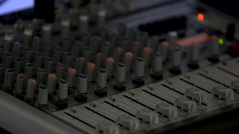 a closeup of a sound board in front of a color changing background