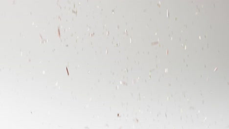 Video-of-glittering-confetti-falling-on-white-background