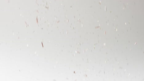 video of glittering confetti falling on white background