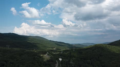 Lufthyperlapse-Sich-Schnell-Bewegender-Wolken-über-Waldgrünen-Hügeln