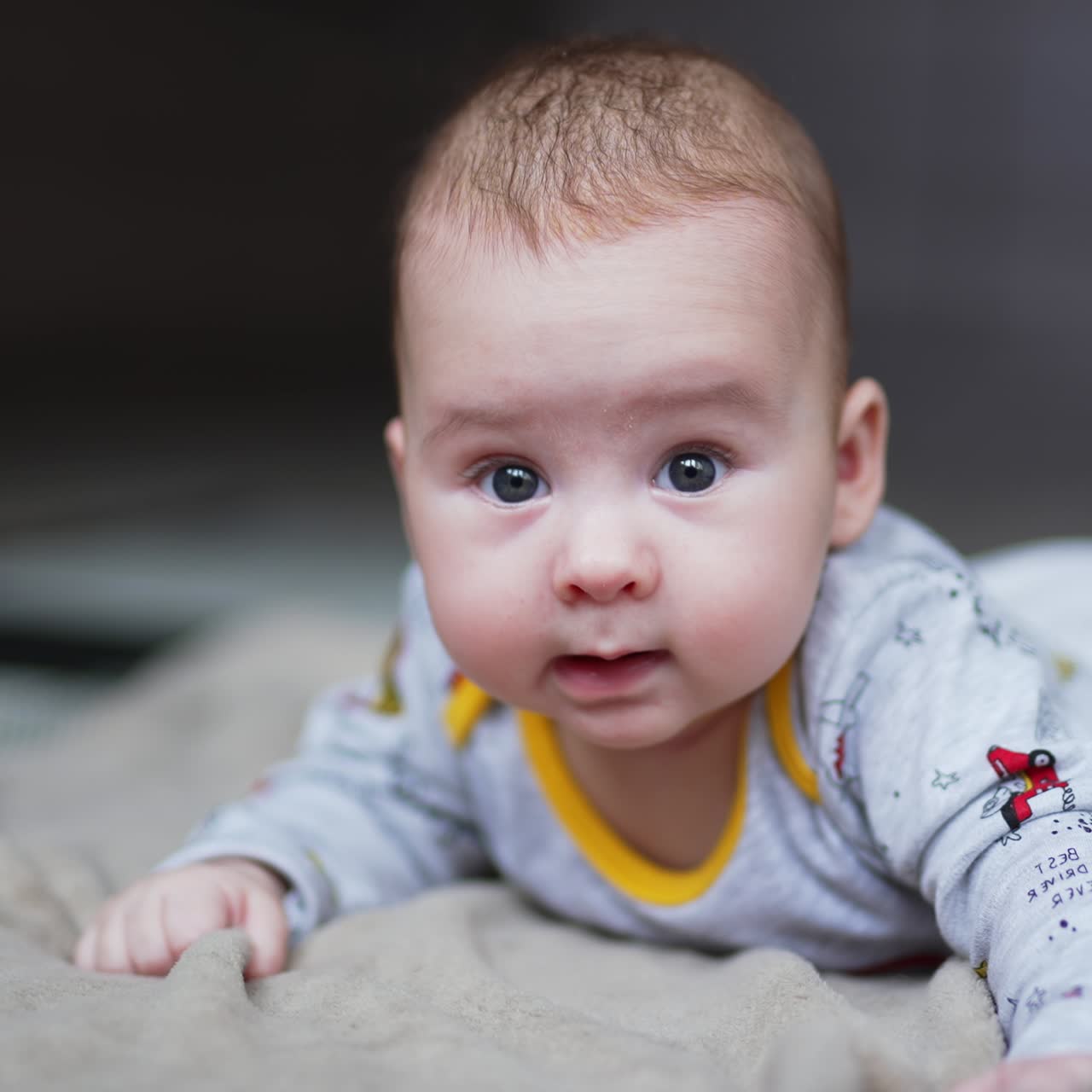Playful baby laying on the bed. Adorable happy little kid smilling