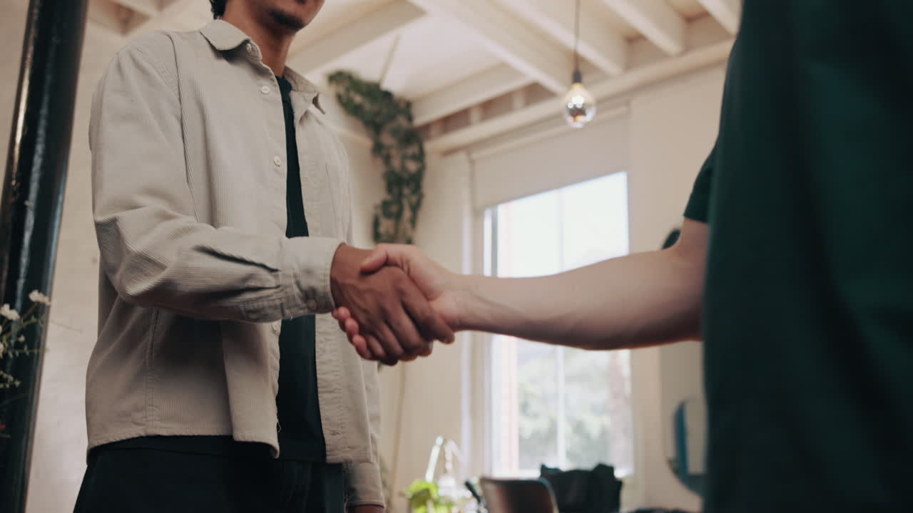 Due uomini che si stringono la mano in un ambiente interno moderno