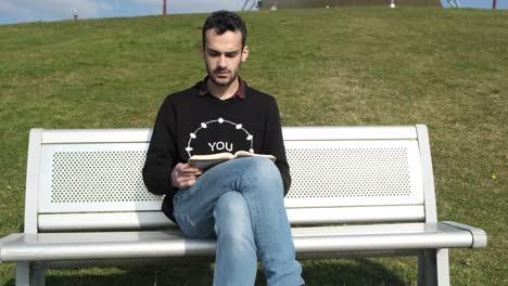 leyendo una novela en el banco blanco