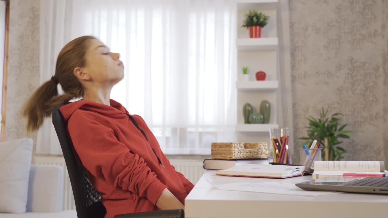 una colegiala aburrida estudiando en casa.