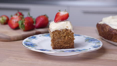 portion of baked carrot cake with fresh sliced strawberry on the top - close up