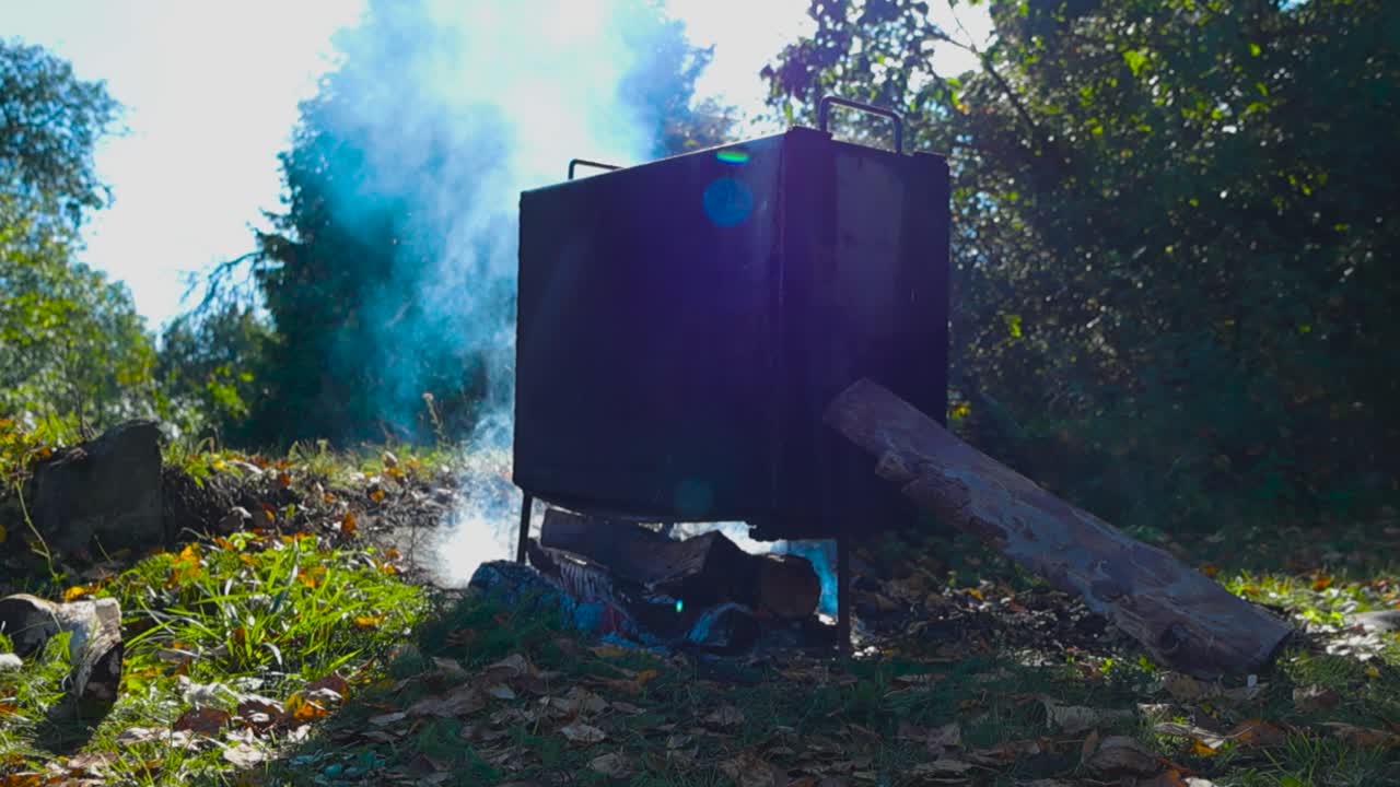 Smoking food in a metal box over an open fire