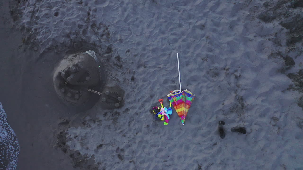 escena de playa con castillo de arena y juguetes