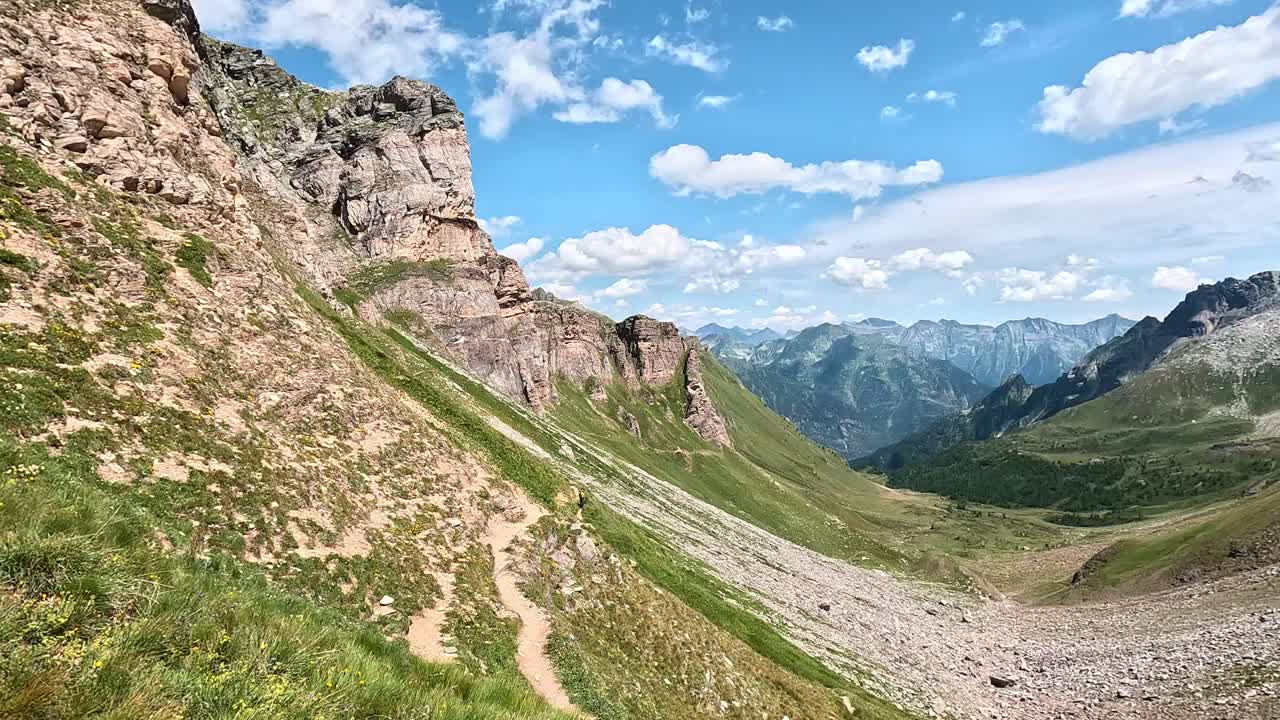 Alpine path leads down from Passo di Valtendra with a wide view toward Alpe Devero and Monte Cistella range
