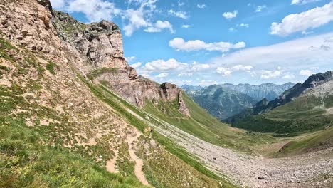 alpine path leads down from passo di valtendra with a wide view toward alpe devero and monte cistella range