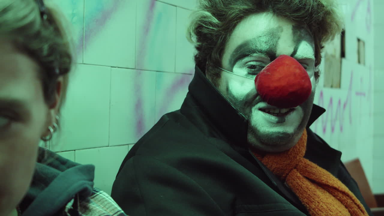 payaso charlando con una mujer alegre en el metro