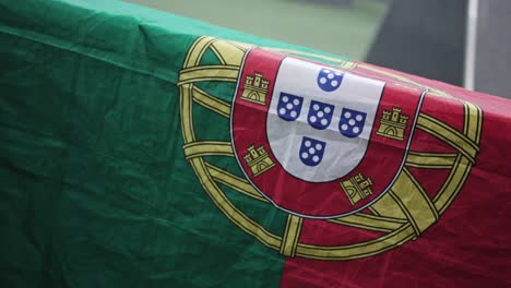 close-up-zoom-out-on-Portuguese-flag-hangs-over-a-table