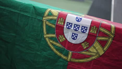 close up zoom out on portuguese flag hangs over a table