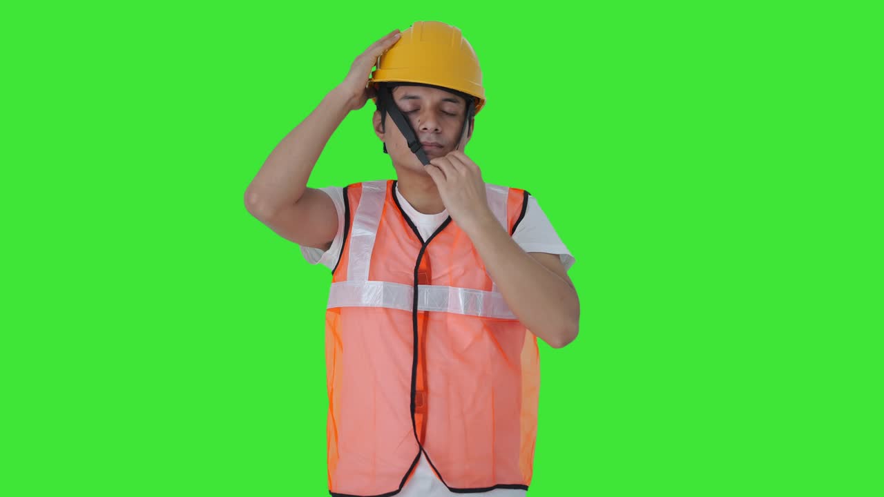 trabajador de la construcción indio con el casco pantalla verde
