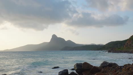 Cinematic-shot-Of-Ocean-Waves-Hitting-The-Rocky-Coastline-Of-Beach-During-Sunset-In-Con-Dao-Archipelago,-Vietnam