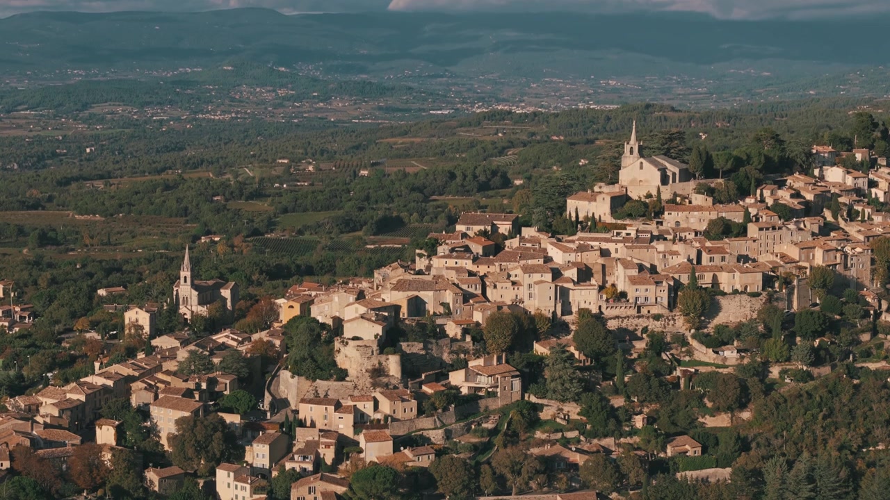 Panoramica aerea discendente di Bonnieux, Francia, che evidenzia chiese in cima alla collina e viste panoramiche.