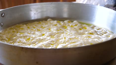 focaccia dough in metal pan before baking close up - cooking