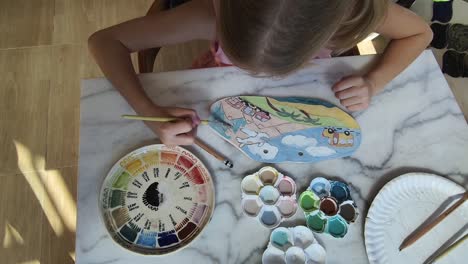 child painting on ceramic tile