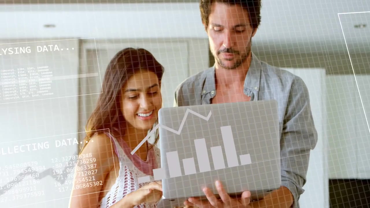 Donna che digita sulla tastiera in cucina, uomo che tiene un laptop, facendo spostare i grafici e analizzando dati tecnologici.