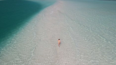 orbit shot of girl walking on the beach in rasdhoo island in maldives