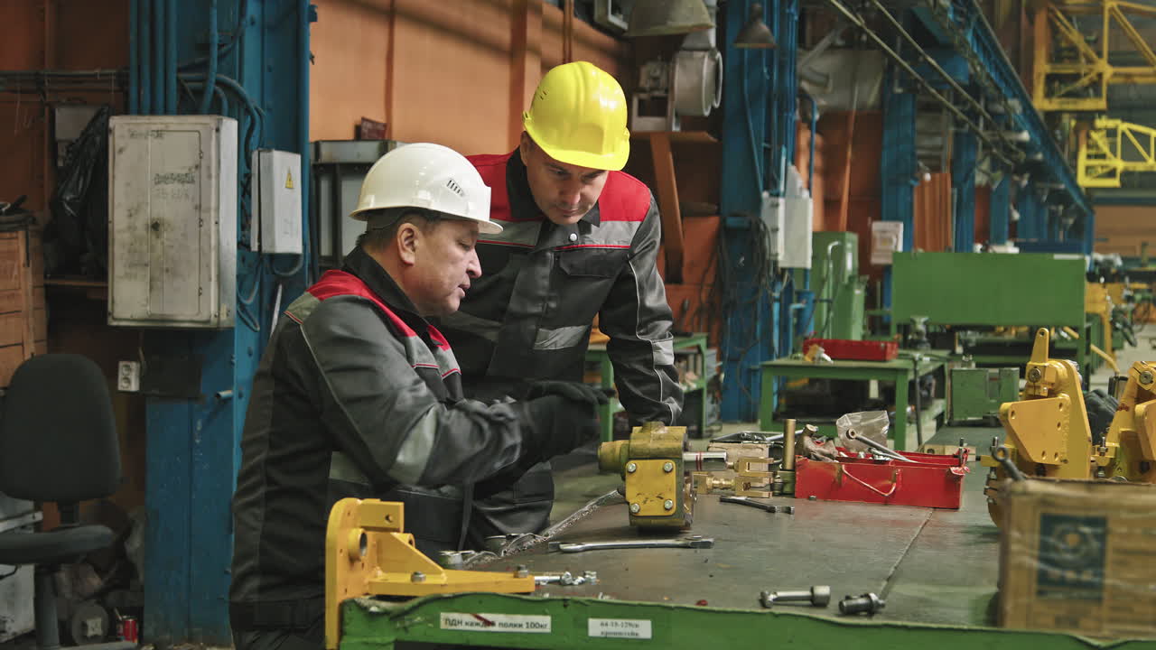 Male Workers Assembling Machinery With Wrench