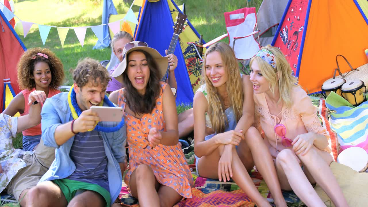 hombre hipster mostrando su teléfono móvil a sus amigos