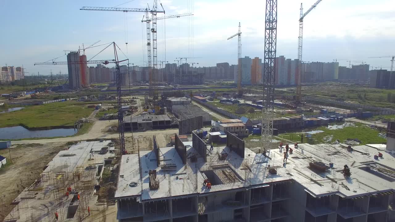 sitio de construcción con grúas y trabajadores