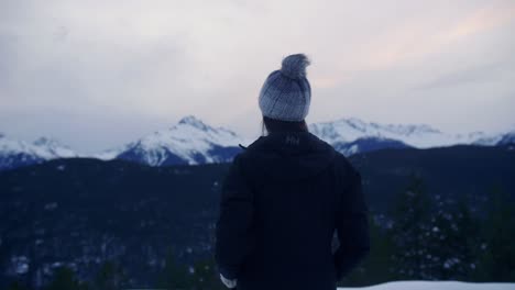 young woman on lookout watching the snow mountain range