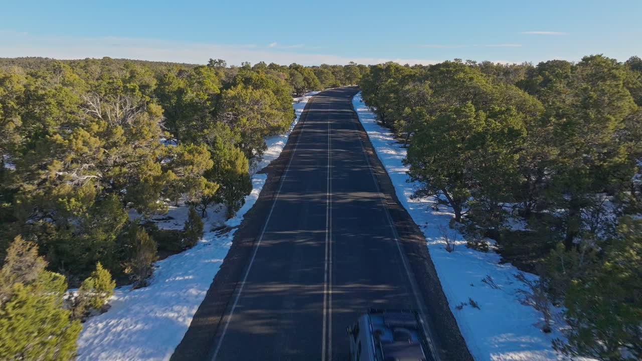 camino pavimentado a través del bosque de nieve hacia los puntos de vista del gran cañón en arizona, ee.