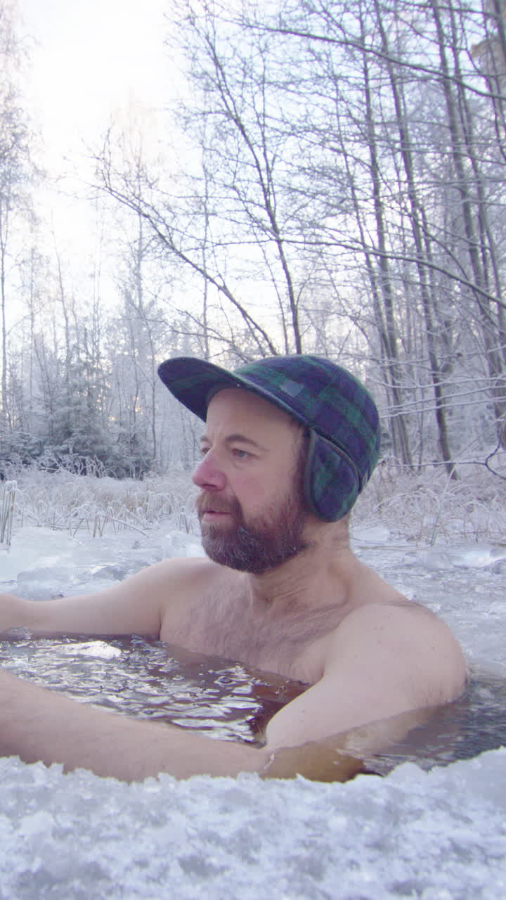 An ice bather steps into ice hole and begins daily cold water exposure, vertical
