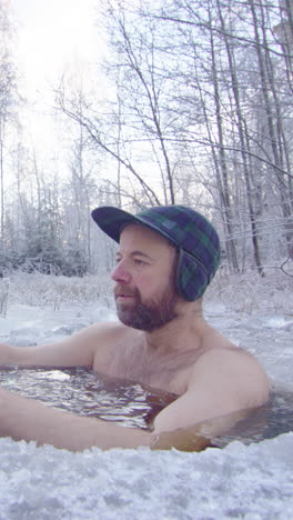 an ice bather steps into ice hole and begins daily cold water exposure, vertical