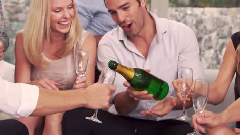 smiling man serving to friends champagne