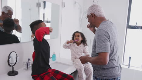 Abuelo-En-El-Baño-En-Pijama-Ayudando-A-Sus-Nietos-A-Cepillarse-Los-Dientes