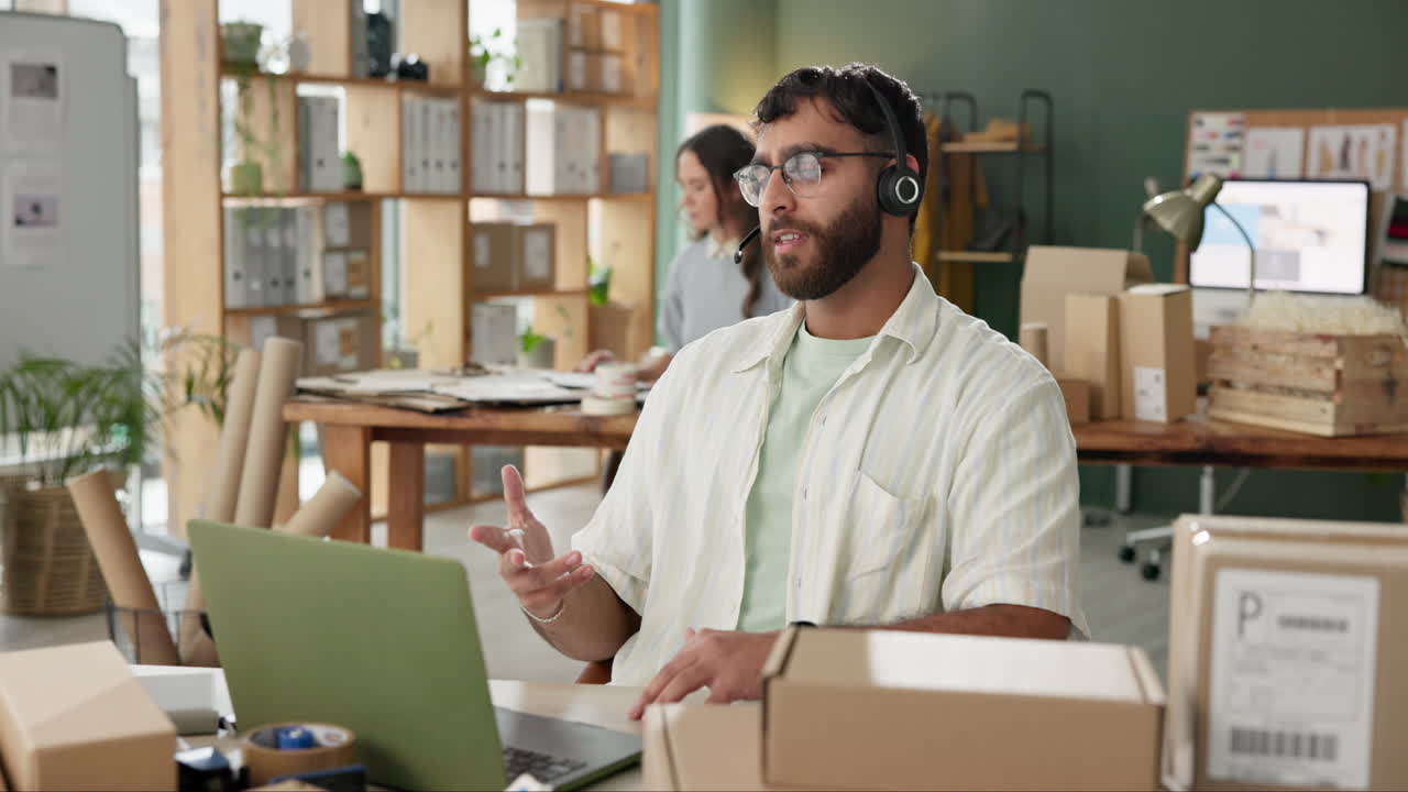 Man with headset in office surrounded by boxes