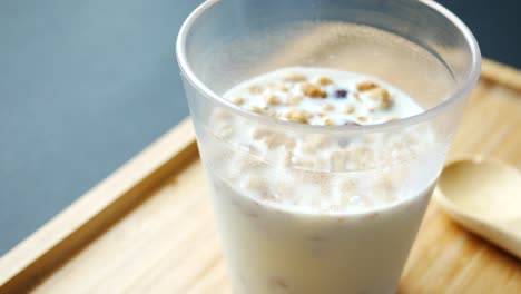 breakfast cereal and milk in a glass on table ,