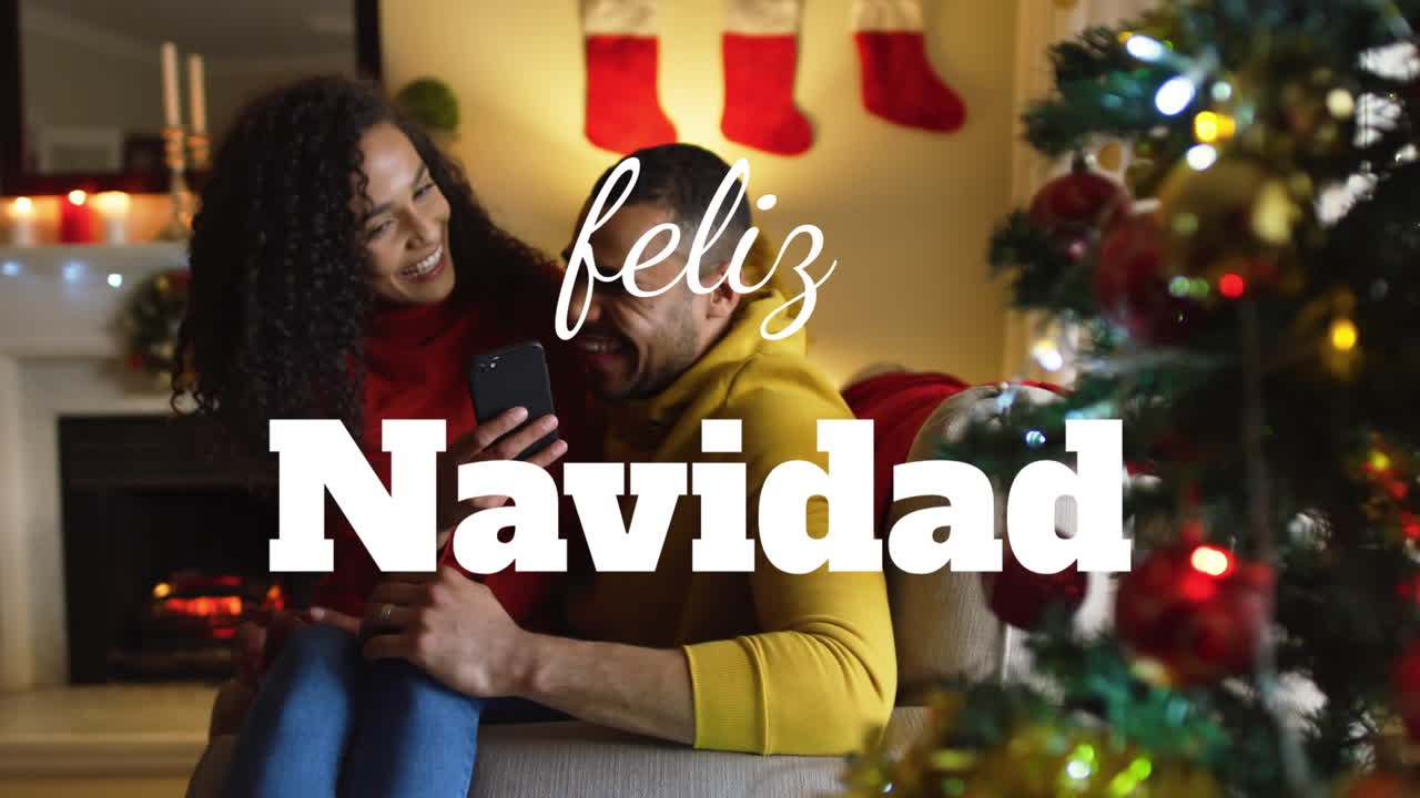 animación de feliz navidad saludos de navidad texto sobre pareja biracial en casa en navidad.