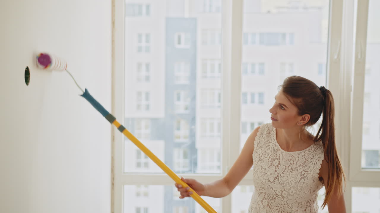 Una mujer pintando una pared.