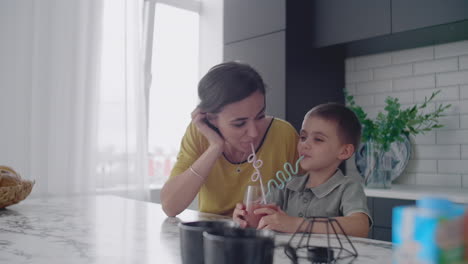 madre y hijo beben el jugo de los tubos